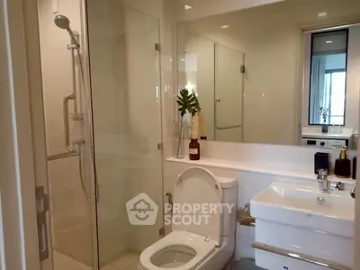 Modern bathroom with glass shower and sleek fixtures in a contemporary apartment.