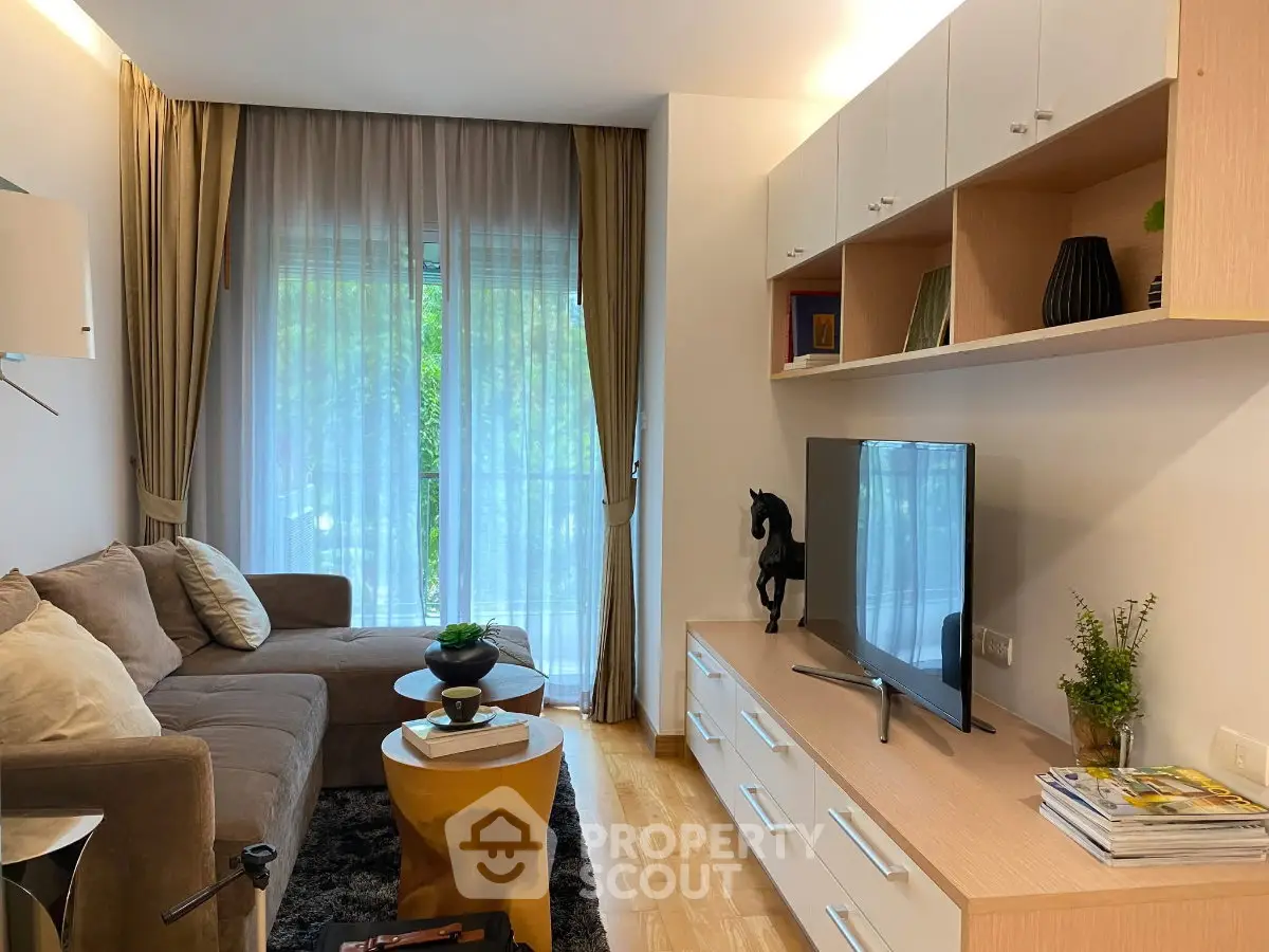 Modern living room with stylish decor, large window, and cozy seating area in a contemporary apartment.