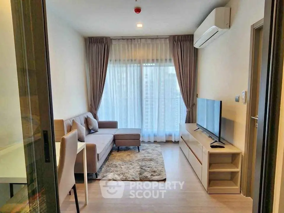 Modern living room with cozy sofa, TV, and large window with curtains in a stylish apartment.