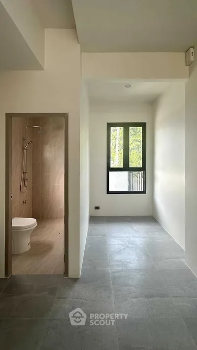 Minimalist bathroom with modern fixtures and large window for natural light.