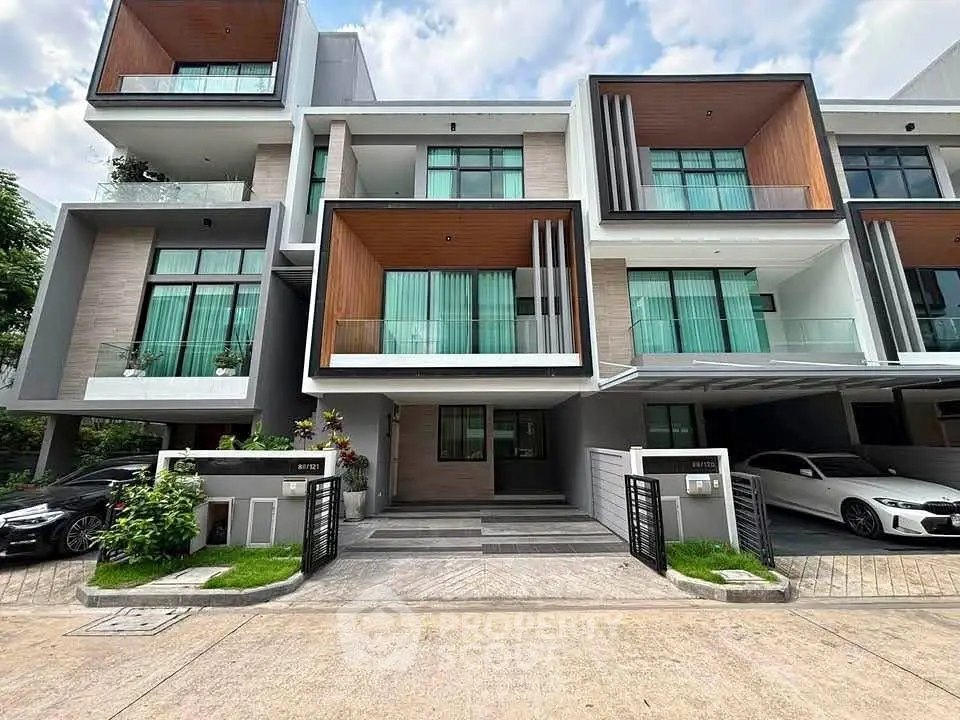Modern multi-level townhouse with sleek design and large windows, featuring a spacious driveway and contemporary facade.
