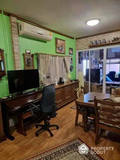 Charming living room with vibrant green walls and cozy decor, perfect for relaxation and entertainment.