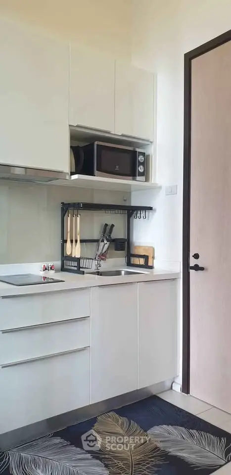 Modern kitchen with sleek white cabinets and built-in microwave