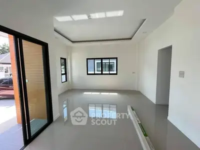 Spacious modern living room with large windows and sleek tile flooring.