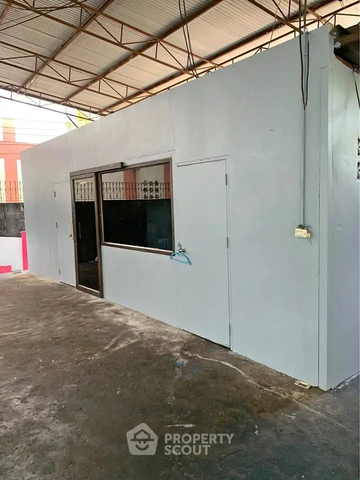 Spacious industrial-style building exterior with metal roof and large windows, ideal for commercial use.