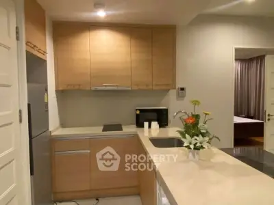 Modern kitchen with sleek cabinetry and integrated appliances in a cozy apartment setting.