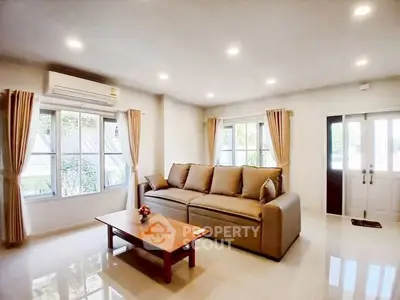 Spacious living room with large sofa and natural light