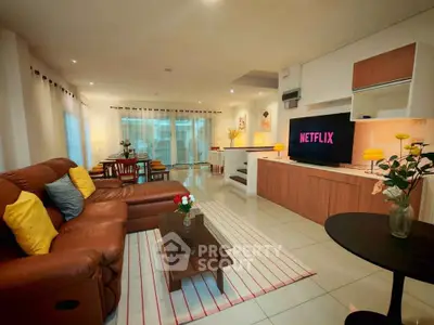 Spacious living room with modern decor and large TV, perfect for entertainment and relaxation.