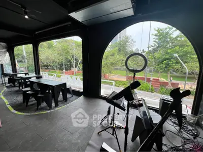 Spacious interior with large windows offering a scenic park view, ideal for versatile use.