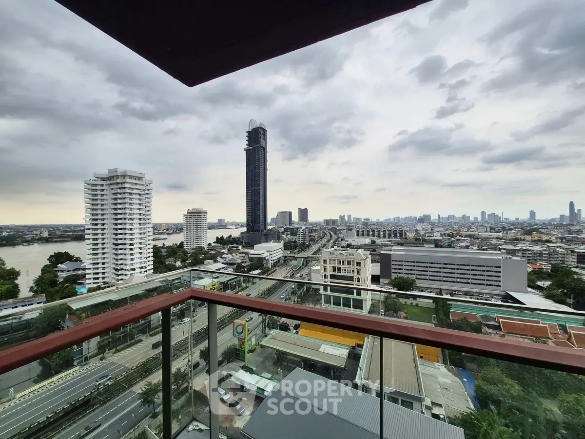 Stunning cityscape view from a high-rise balcony overlooking urban skyline and river.