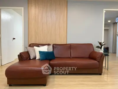 Stylish living room with modern leather sofa and wooden accents