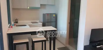 Modern compact kitchen with breakfast bar and sleek appliances in cozy apartment