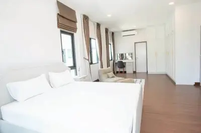 Spacious modern bedroom with elegant decor and ample natural light