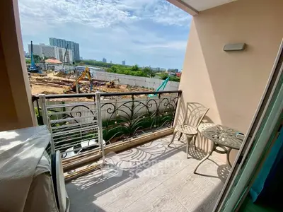 Charming balcony with stylish railing and outdoor seating, overlooking construction and cityscape.