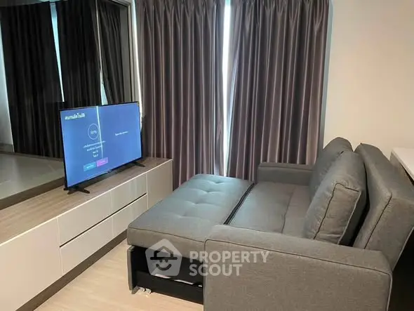 Modern living room with sleek furniture and large TV, perfect for relaxation and entertainment.