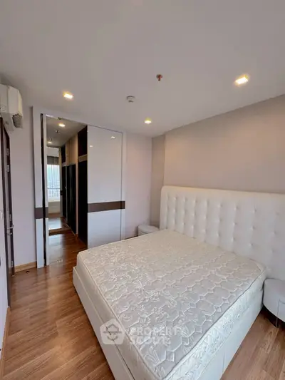 Spacious bedroom with elegant design and ample natural light, featuring a large bed and modern wardrobe.