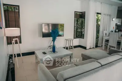 Stylish modern living room with cozy sofa and flat-screen TV, perfect for relaxation.