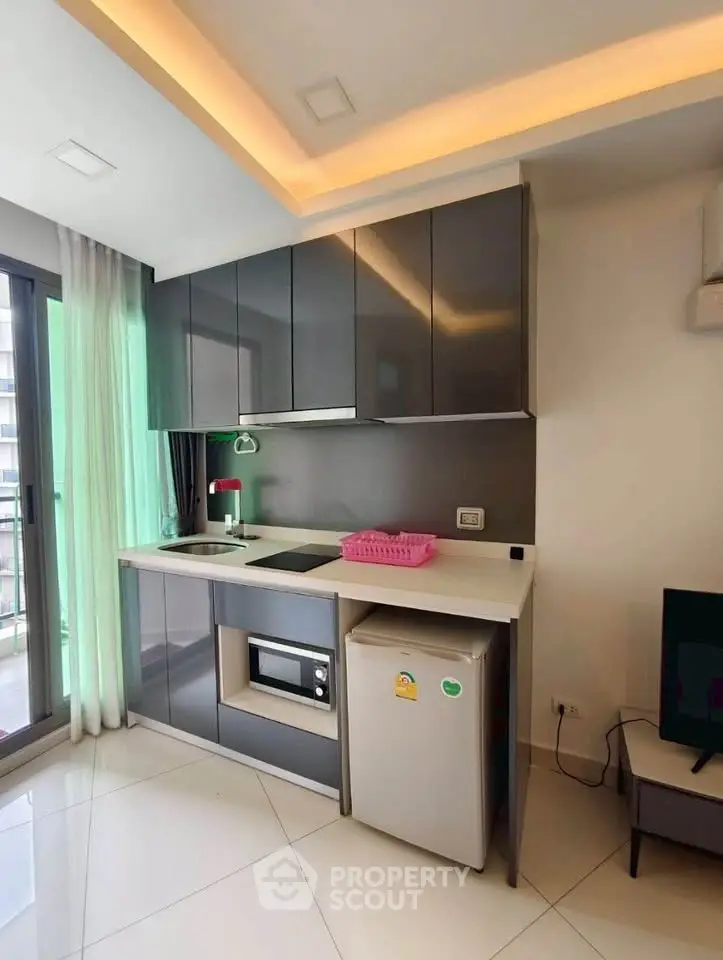 Modern compact kitchen with sleek cabinets and appliances in a stylish apartment