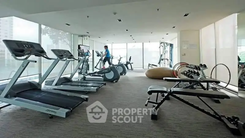 Spacious modern gym with state-of-the-art equipment and panoramic windows.