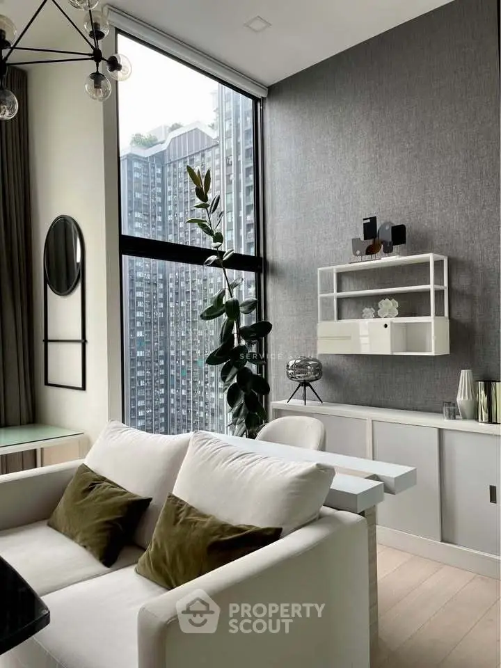 Modern living room with high ceilings and large windows offering city views, featuring stylish decor and comfortable seating.