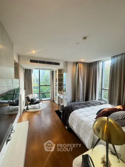 Luxurious bedroom with modern decor and large windows offering a serene view.