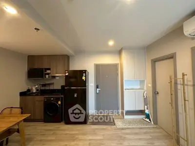 Modern kitchen with black appliances and wooden cabinetry in open layout apartment.