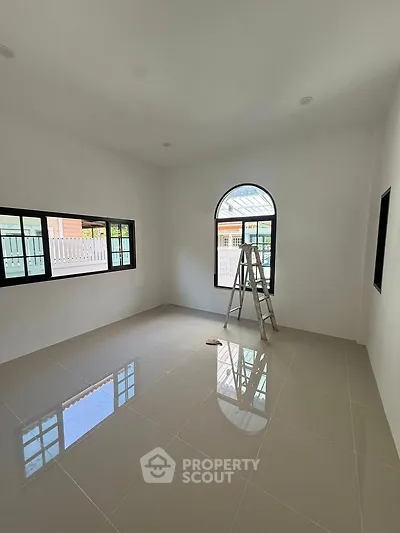 Bright empty room with large windows and glossy tiled floor, perfect for customization.