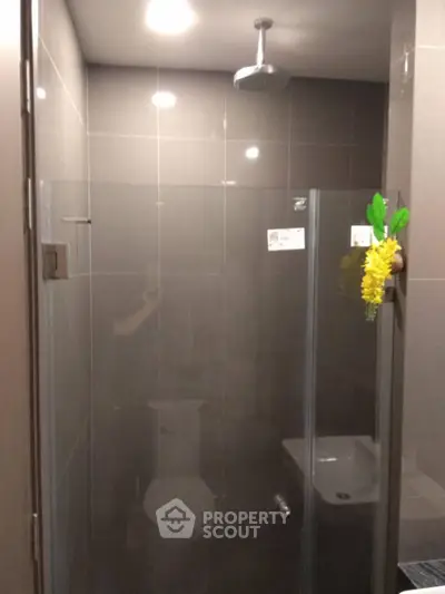 Modern bathroom with glass shower enclosure and overhead showerhead.