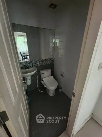 Compact bathroom with modern fixtures and large mirror, ideal for efficient space usage.