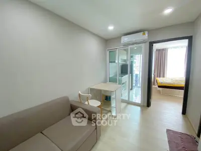 Modern compact living room with sofa and open kitchen layout in bright apartment