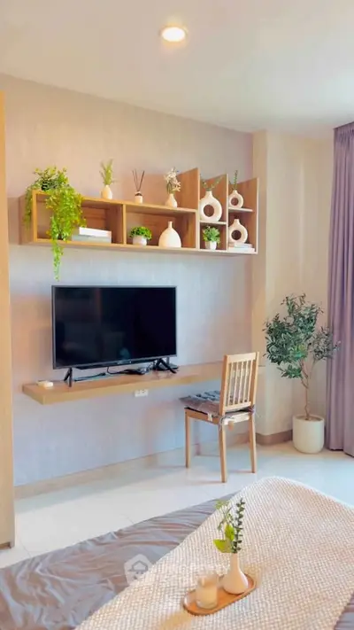 Modern bedroom with stylish decor, wall-mounted TV, and elegant shelving in a cozy apartment.