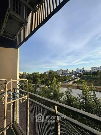 Spacious balcony with scenic city view and lush greenery, perfect for relaxation and outdoor enjoyment.