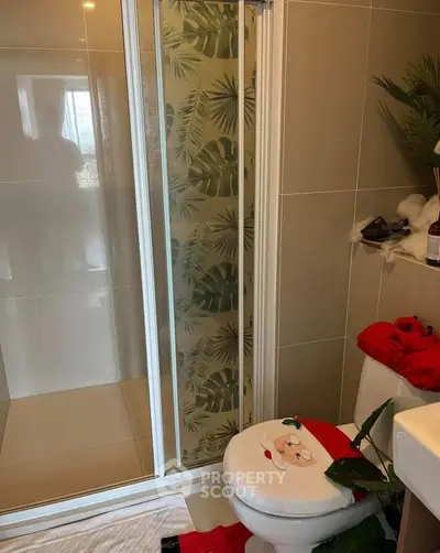 Charming bathroom with tropical-themed shower and festive decor, perfect for cozy living.
