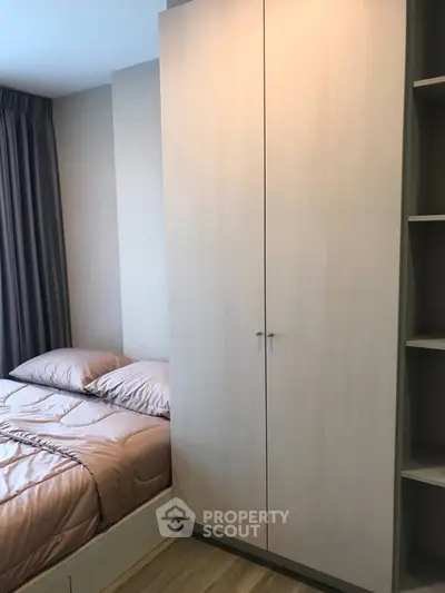 Cozy bedroom with modern wardrobe and soft bedding in a stylish apartment.
