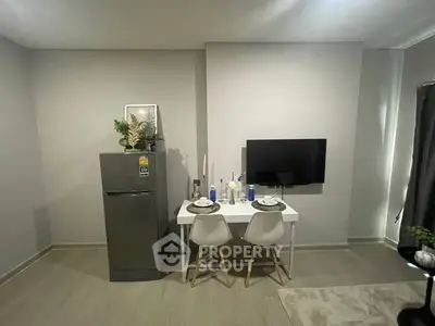 Modern dining area with compact fridge and wall-mounted TV in minimalist apartment.