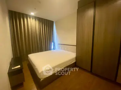 Cozy bedroom with wooden flooring and large wardrobe in modern apartment