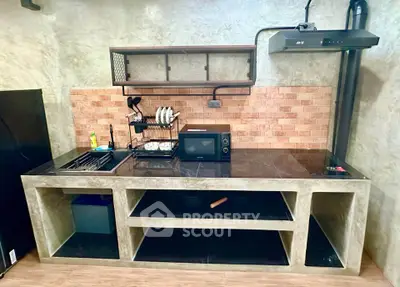 Modern industrial kitchen with concrete countertops and brick backsplash