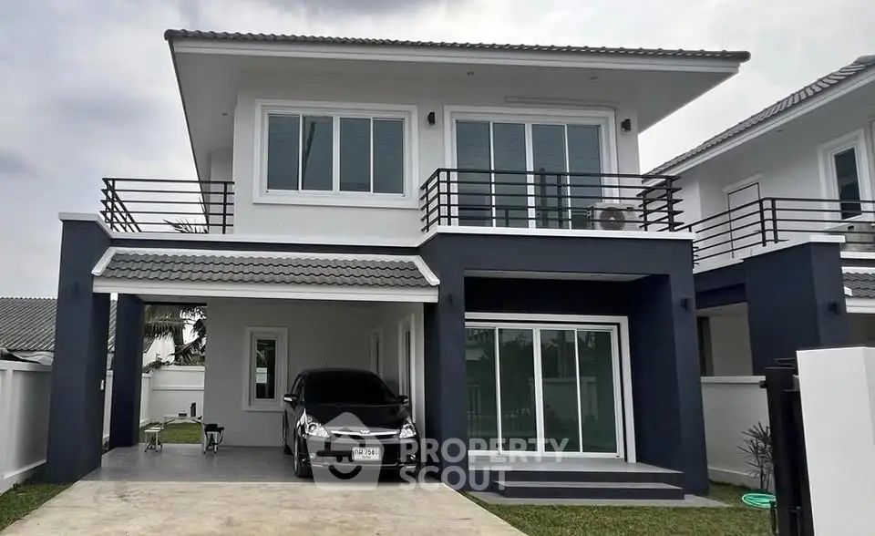 Modern two-story house with sleek design and carport in suburban neighborhood.