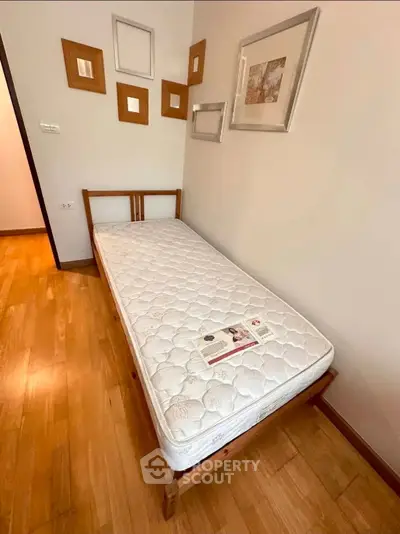 Cozy bedroom with single bed and stylish wall decor in modern apartment.