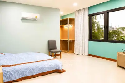 Spacious bedroom with large window and built-in closet, perfect for natural light lovers.