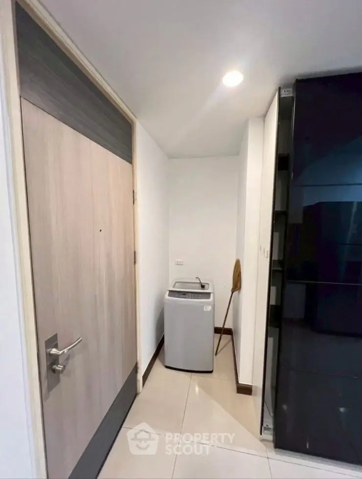 Compact laundry area with washing machine in modern apartment hallway
