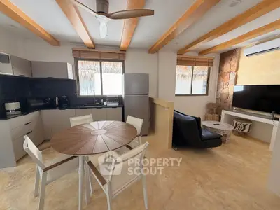 Modern open-plan living room with kitchen, featuring wooden beams and stylish furniture.