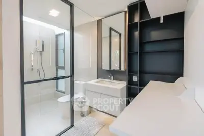 Modern bathroom with sleek design, glass shower, and ample storage space.