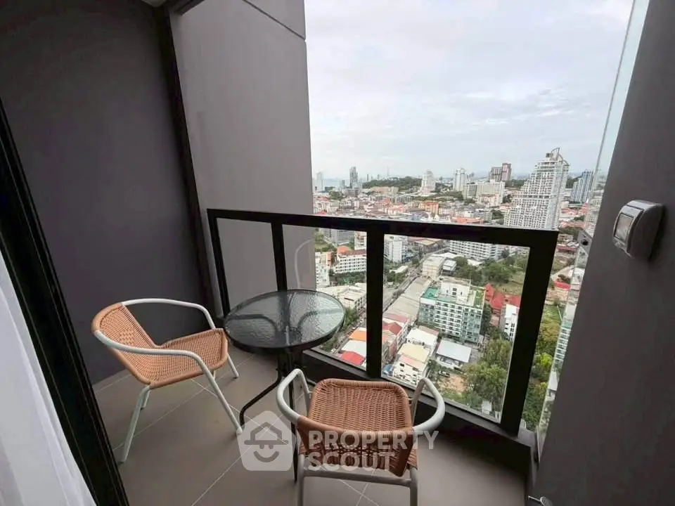Stunning high-rise balcony with cityscape view, perfect for relaxation and enjoying urban living.