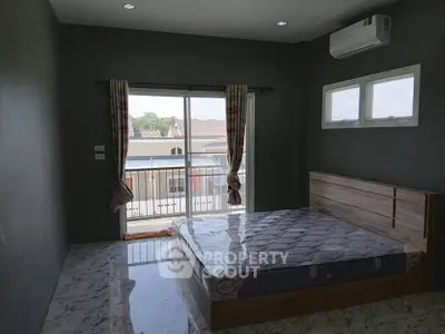Spacious bedroom with large window and balcony access, featuring modern air conditioning and elegant marble flooring.
