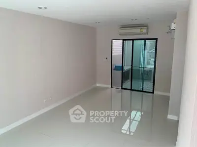 Spacious unfurnished living room with air conditioning and sliding glass door to balcony.