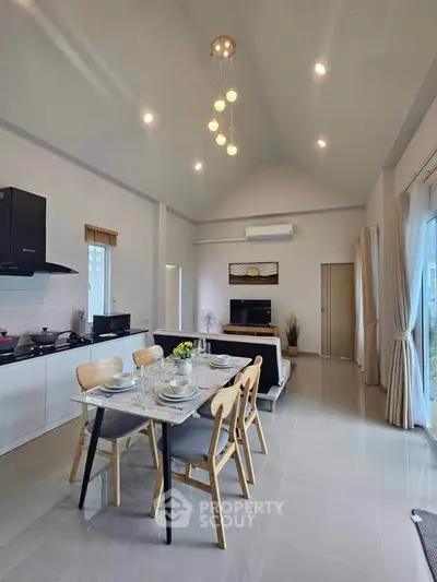 Spacious open-plan living and dining area with modern kitchen and elegant decor.