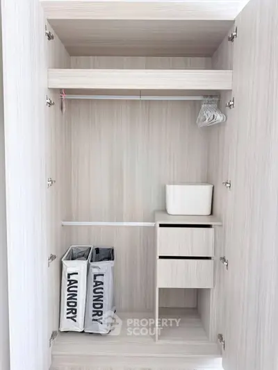 Spacious modern wardrobe with laundry bins and storage drawers in a sleek design.