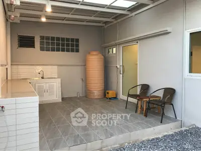 Spacious outdoor patio with tiled flooring and seating area, perfect for relaxation.