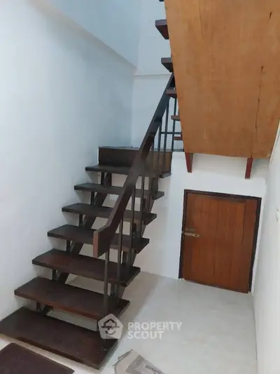 Modern interior staircase with wooden steps and metal railing in a minimalist home